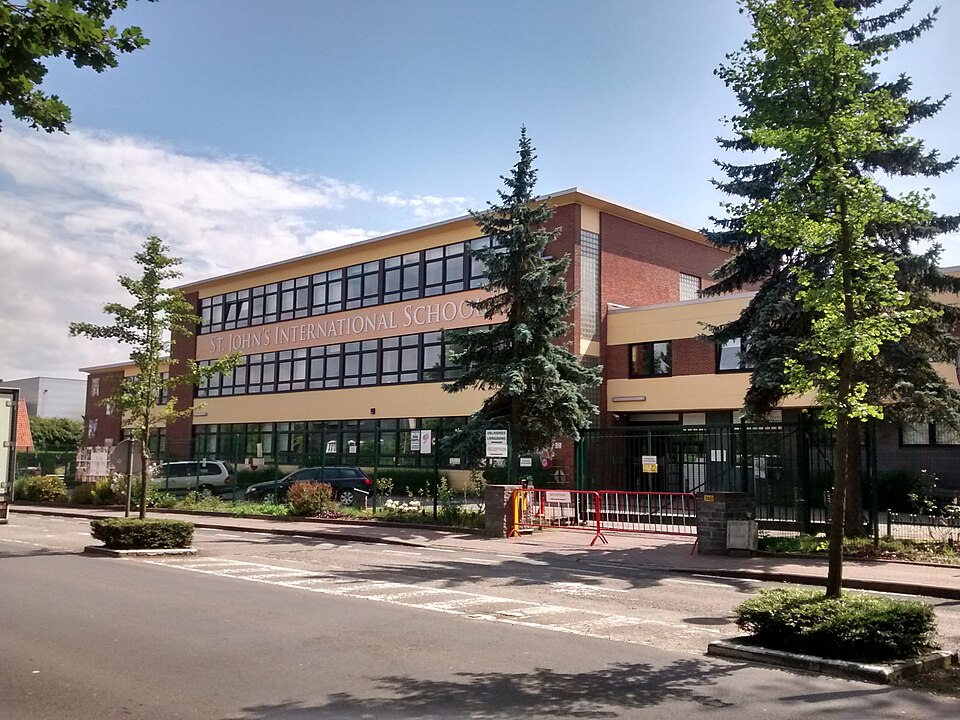 ST. JOHN'S INTERNATIONAL SCHOOL 교명이 걸린 벨기에 워털루의 붉은 벽돌 교사 건물